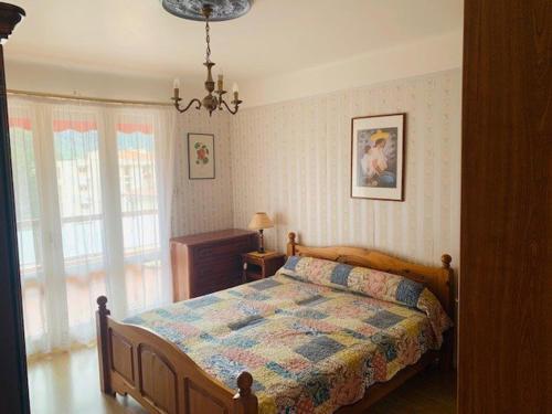 une chambre avec un lit et un lustre dans l'établissement Appartement F3 avec Terrasse, Garage et Wifi - 4 Couchages - Proche Cures et Centre Ville - FR-1-703-113, à Amélie-les-Bains-Palalda