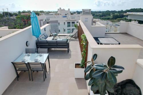 a balcony with a table and chairs and an umbrella at Luxurious flat & private rooftop in Villamartin Orihuela Costa in Orihuela Costa