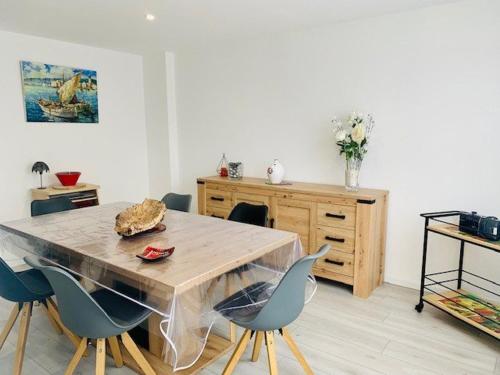 une salle à manger avec une table et des chaises en bois dans l'établissement Charmant F3 climatisé avec balcon ensoleillé, proche centre et Thermes - Amélie-les-Bains - FR-1-703-80, à Amélie-les-Bains-Palalda