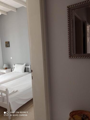 a bedroom with a bed and a mirror on the wall at Angelik Ipsos no5 in Ýpsos