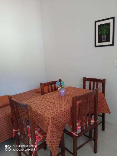 a dining room table with a orange table cloth and chairs at Angelik Ipsos no5 in Ýpsos
