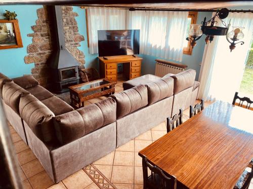 a living room with a large couch and a table at Apartamentos Els Ocells in Camprodon