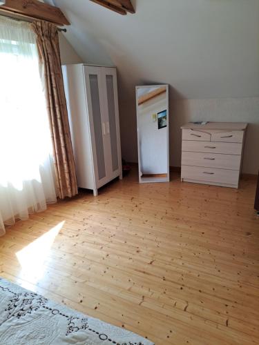 an empty room with a refrigerator and a dresser at Apartamentai Tigro guolis Rusnėje in Rusnė