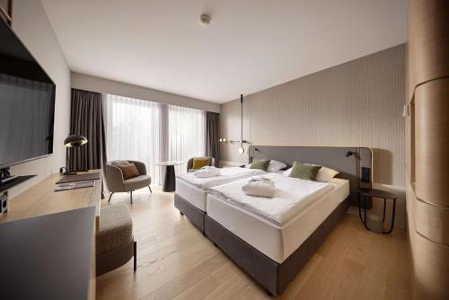 um quarto com uma grande cama branca num quarto em ATLANTIC Hotel Heidelberg em Heidelberg
