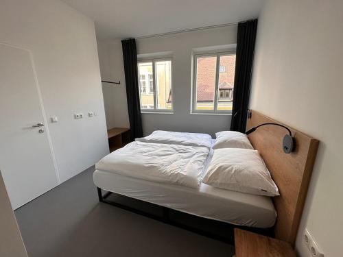 Bett in einem Zimmer mit Fenster in der Unterkunft Rilke Apartments in Linz