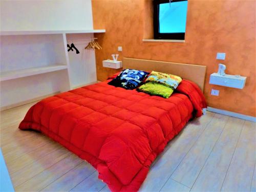 a red bed in a room with a television at Regina Viarum Apartment, Historic City Centre in Brindisi