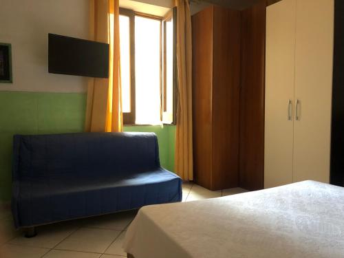 um quarto com uma cadeira azul e uma janela em ZIO DOMENICO Al Vicolo em Castellabate