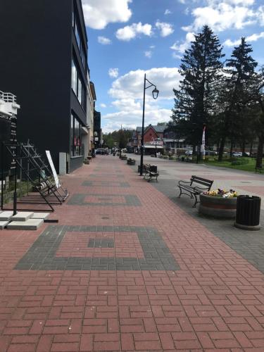 a brick sidewalk with benches on a city street at Apartament Vistula Centrum 4 in Wisła