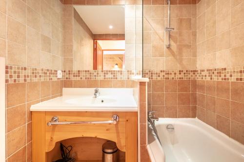 a bathroom with a sink and a bath tub at Les Alpages du Corbier C101 in Villarembert