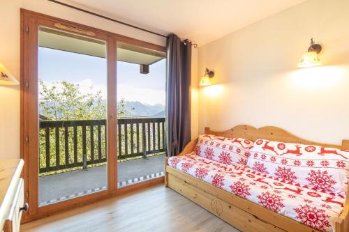 a bedroom with a bed and a balcony at Les Alpages du Corbier C101 in Villarembert