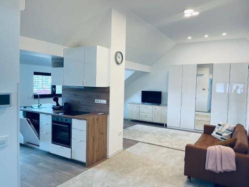 a kitchen with white cabinets and a couch in a room at Villa Kovačeva 15, app 2, free parking in Ljubljana