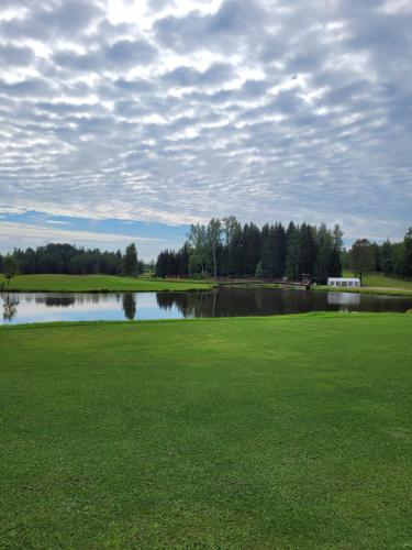 Indrāni的住宿－Brīvdienu namiņi Kalnozoli，享有高尔夫球场和湖泊的景色