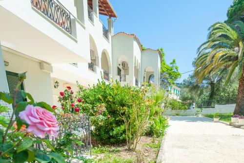 a building with flowers in front of it at Vassilis Paradise Garden Aparthotel in Agios Georgios Pagon