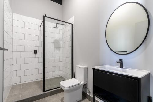 a bathroom with a toilet and a sink and a mirror at BlackBrick Cape Town Foreshore in Cape Town