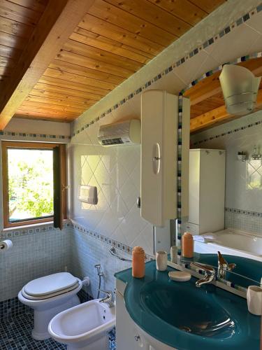 uma casa de banho com um lavatório verde e um WC em Casa Vittoria em Vietri