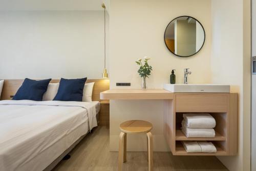 a bedroom with a bed and a sink and a mirror at Hotel Ever Spring - Penghu in Magong
