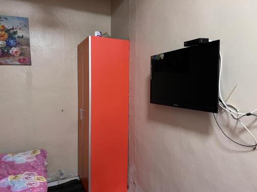 En TV eller et underholdningssystem på OYO 90797 Napoh Motel
