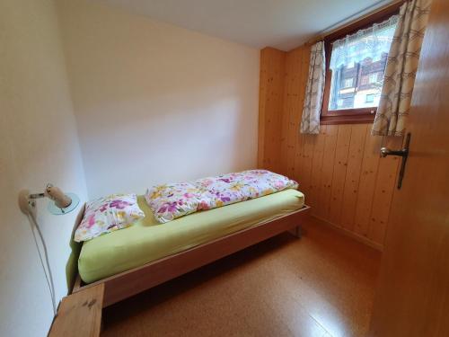 ein kleines Bett in einem Zimmer mit Fenster in der Unterkunft Gadä 2 in Reckingen - Gluringen