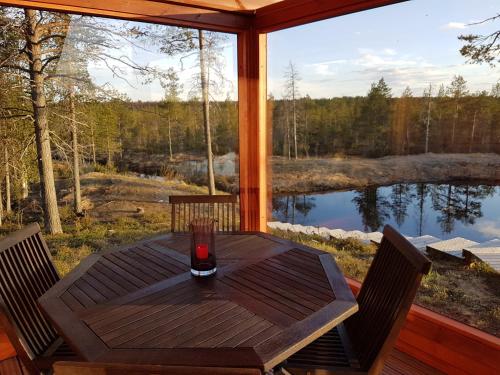 a table on a screened in porch with a view of a lake at Villa Kanger in Kuusamo
