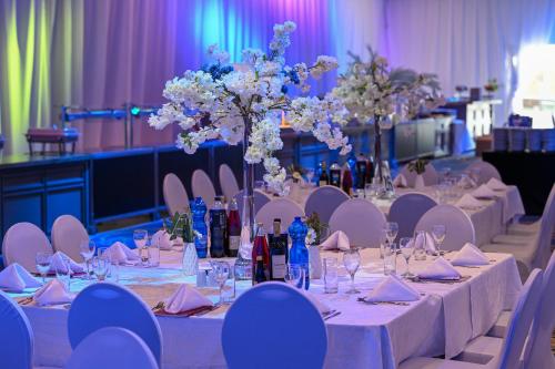 a table set up for a wedding with white tables and flowers at Leonardo Club Eilat - All Inclusive in Eilat