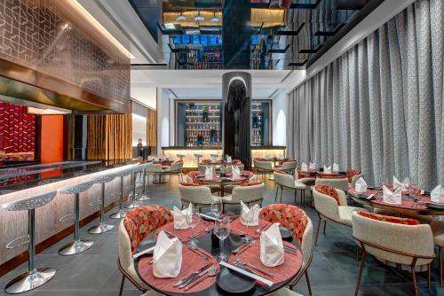 a restaurant with tables and chairs and a bar at Royal M Al Aqah Beach Resort by Gewan in Al Aqah