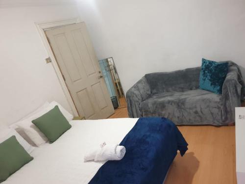 ロンドンにあるBalham, South London Spacious Guest House F2, 6 rooms availableのベッドとソファのあるリビングルーム
