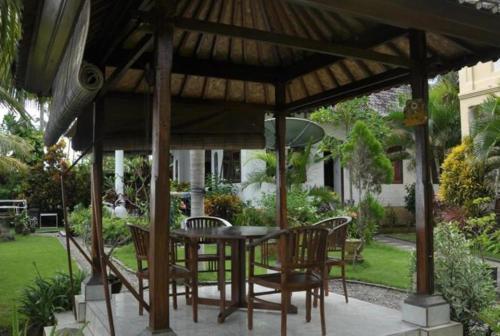 a patio with a table and chairs under a pavilion at Crystal Beach Bali in Candidasa