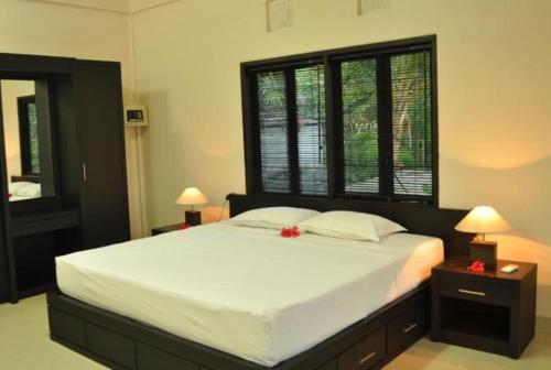 a bedroom with a large white bed with flowers on it at Crystal Beach Bali in Candidasa