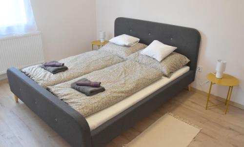 1 dormitorio con 1 cama grande con 2 almohadas en Vöröskő Apartmanház, en Balatonalmádi