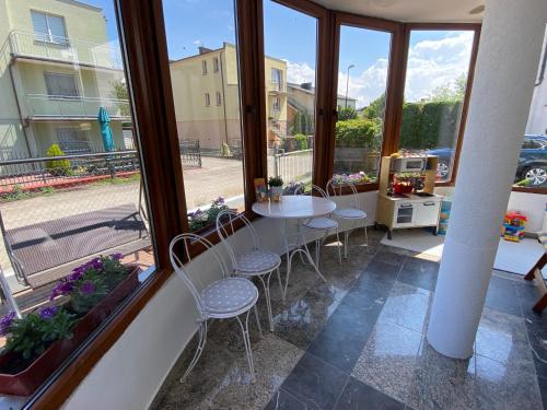 a balcony with a table and chairs and windows at Willa Ada in Karwia