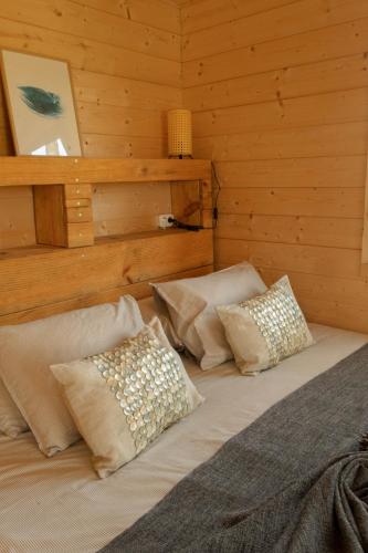 a bed in a wooden room with pillows on it at Soul Farm Algarve - Glamping & Farm Houses in Aljezur