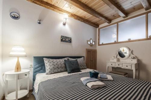 a bedroom with a bed and a lamp and a mirror at Dream on a wave in Skiathos