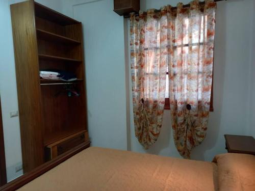 a bedroom with a bed and a dresser and curtains at Domus Shardana in Gonnesa