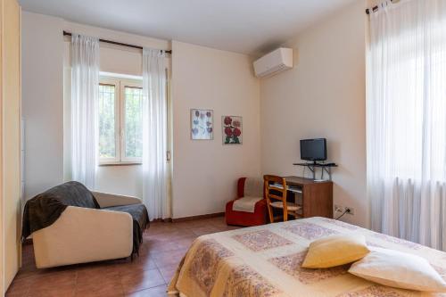 een slaapkamer met een bed, een stoel en een televisie bij Le Anfore di Arpi in Foggia