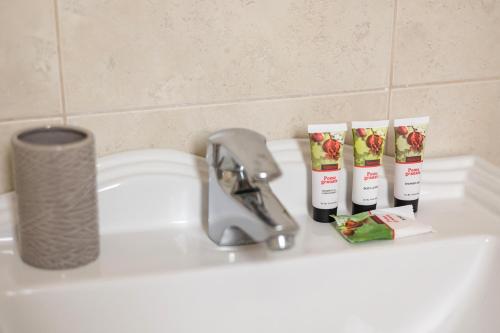 Un lavabo con cepillos de dientes y pasta de dientes encima. en Villa Thea, en Afantou