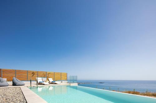 a swimming pool with a view of the ocean at Krystallon Villas in Palaiochóra