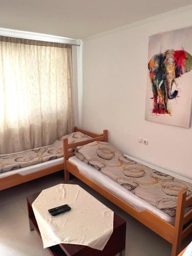a room with two beds and a painting of an elephant at Villa Ami in Novi Sad