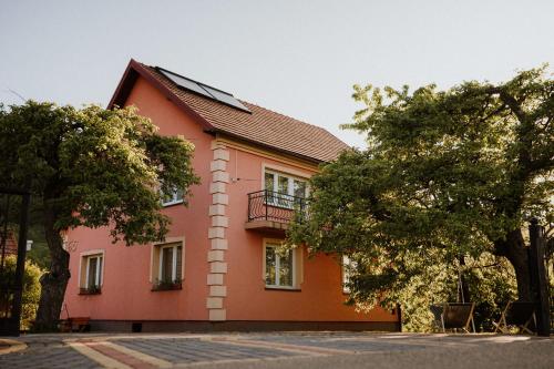 una casa rossa con un balcone sul lato di Dom pod Jabłoniami a Łukowica