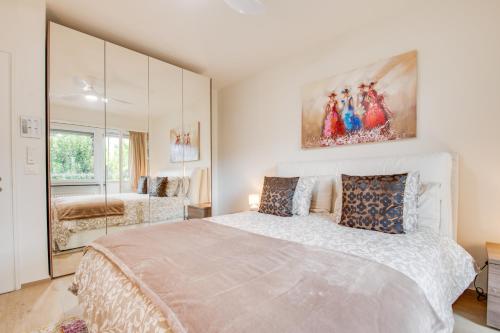 - une chambre blanche avec un grand lit et un miroir dans l'établissement RELAX Camelia Apartment, à Locarno