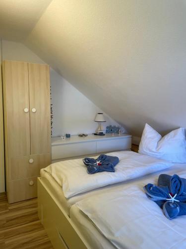 a bedroom with two beds with blue bows on them at Ankerplatz38 in Trassenheide