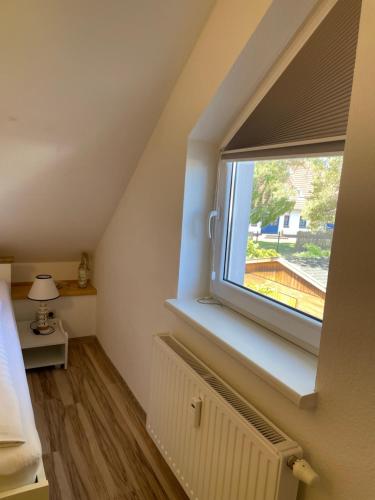 a bedroom with a large window in a attic at Ankerplatz38 in Trassenheide