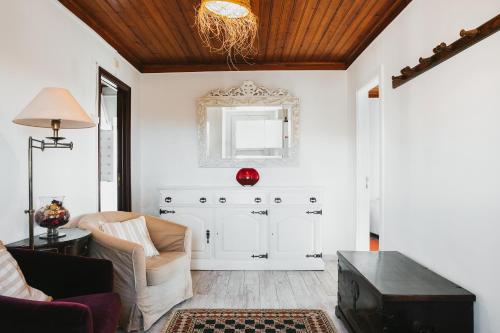 - un salon avec une chaise et un miroir dans l'établissement Bird House, à Lourinhã
