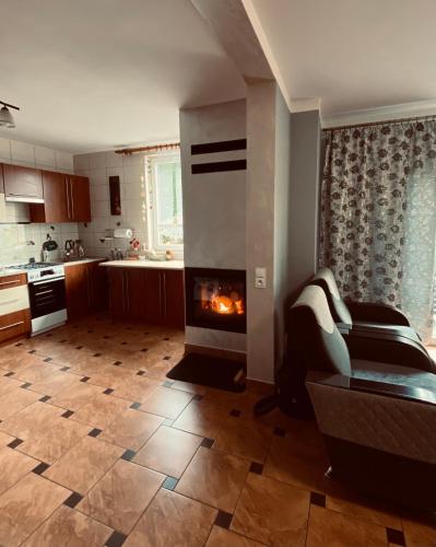 a kitchen with a fireplace in a living room at Agroturystyka ‚U Misia’ in Krzywopłoty