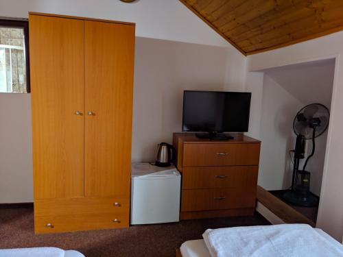 a bedroom with a tv and a dresser with a dresser at Pension Casa Samurai in Braşov