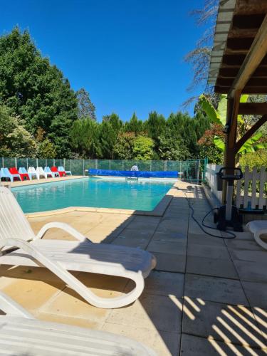 uma piscina com uma espreguiçadeira branca ao lado em Château La Barge - Dordogne em La Boissière-dʼAns