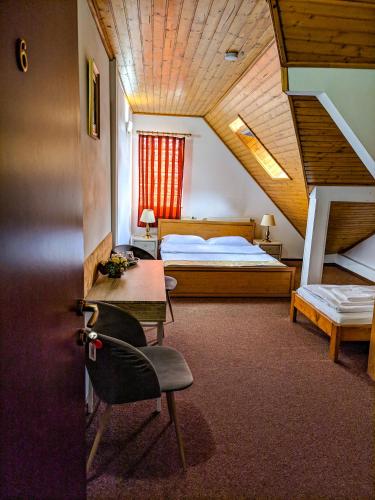 a bedroom with a bed and a desk and a staircase at Pension Casa Samurai in Braşov