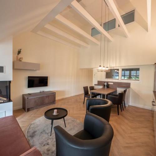 a living room with couches and a table and chairs at Ferienwohnung "Landhaus Buchenallee" in Bad Bentheim
