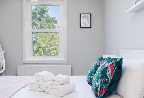 un mucchio di asciugamani seduti sopra un letto di WelcomeStay Colliers Wood Two Bed Apartment - Home Away from Home a Londra