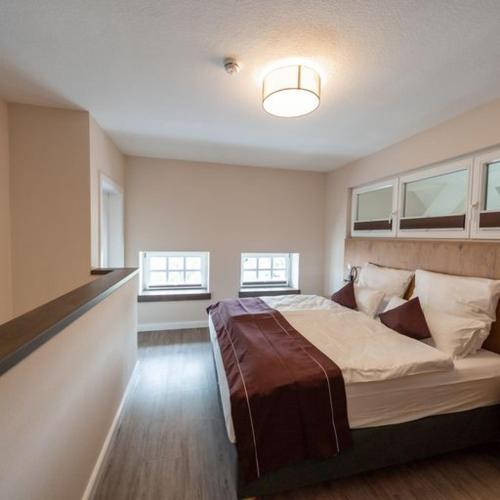 a bedroom with a large bed in a room with windows at Ferienwohnung "Landhaus Buchenallee" in Bad Bentheim