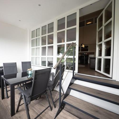 a room with a table and chairs on a balcony at Ferienwohnung "Landhaus Buchenallee" in Bad Bentheim